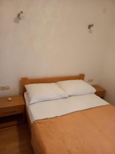 una camera da letto con un letto con lenzuola bianche e due tavoli di Žulj Vodice a Vodice