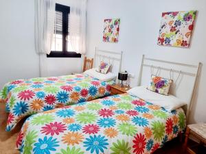 2 camas en una habitación con sábanas coloridas en Sheron's Apartment, en Los Alcázares