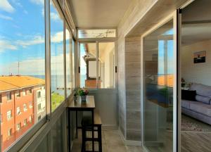 Habitación con ventanas grandes y mesa con vistas. en Arribolas, en Bermeo