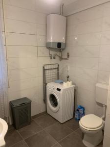 a bathroom with a washing machine and a toilet at Apartment Rose II in Zagreb