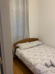 a small bed in a room with a curtain at Apartment Rose II in Zagreb