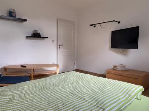 a bedroom with a bed and a table and a flat screen tv at Wohnung an der Mühle in Eystrup