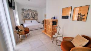 a hotel room with a bed and a couch and chairs at OPUNTIA Hotel Boutique in Mijas