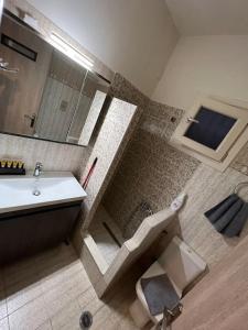 a bathroom with a toilet and a sink and a shower at Corner House Volos in Volos