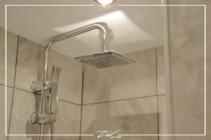 een douche met een douchekop in de badkamer bij Vel Boutique Suites in Agia Galini