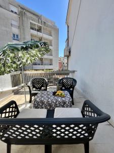 a table and chairs on a balcony with a table and bananas at Villa Merci Budva in Budva
