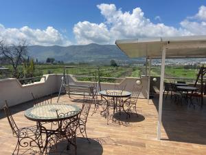 a patio with tables and chairs on a deck with a view at Gross Nofesh and Spa Guesthouse in Bet Hillel