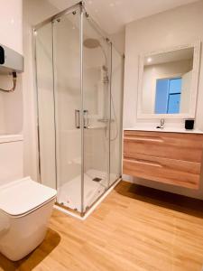 a bathroom with a shower with a toilet and a sink at Bonito Apartamento Conil CALEFACCIÓN Y WIFI -SOLO FAMILIAS Y PAREJAS- in Conil de la Frontera