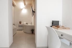 a white bathroom with a sink and a tub at TS ROOMS - Guest House Sciola in San Sperate