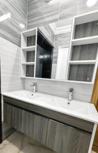 een badkamer met een wastafel en een spiegel bij Batw باتوا لشقق المخدومة in Al Baha