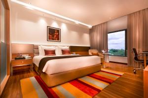 a bedroom with a large bed and a large window at Grand Chennai by GRT Hotels in Chennai
