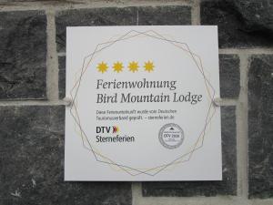 a sign for a bird mountain lodge on a brick wall at Bird Mountain Lodge am Vulkanradweg - keine Monteure 