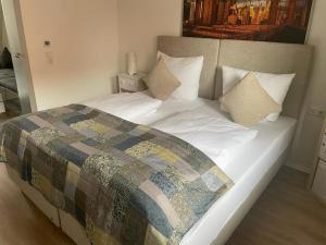 ein großes Bett mit einer Decke in einem Schlafzimmer in der Unterkunft Ferienwohnung An der alten Weed in Bad Windsheim
