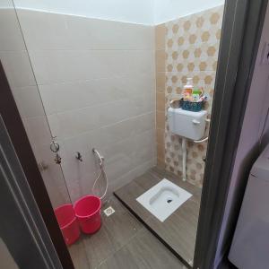 a small bathroom with a toilet and buckets in it at Homestay Cikgu Fatiah in Kota Bharu