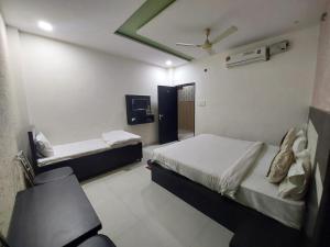 1 dormitorio con 2 camas y ventilador de techo en Rama HS, en Agra