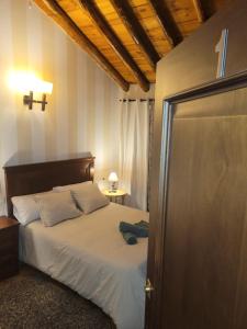 een slaapkamer met een bed en een deur naar een kamer bij Habitaciones La Flamenka in Ronda
