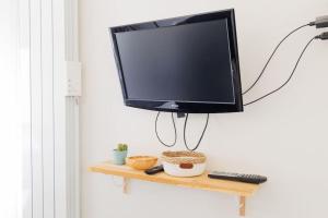 a flat screen tv hanging on a wall at L'appart Cosy -Proche Disney in Mareuil-lès-Meaux
