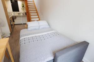 Cama grande en habitación con escalera en L'appart Cosy -Proche Disney en Mareuil-lès-Meaux