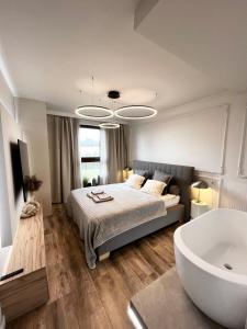 a bedroom with a large bed and a bath tub at Apartament nad jeziorem Drwęckim Oaza in Ostróda