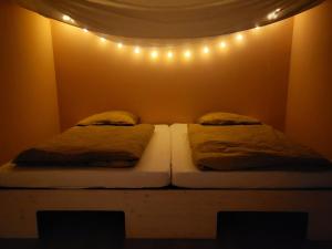 two beds in a room with lights on the wall at Gästehaus am Weser-Radweg in Hannoversch Münden