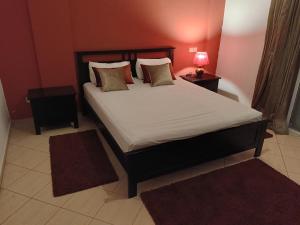 ein Schlafzimmer mit einem Bett mit zwei Tischen und einer Lampe in der Unterkunft Appart Majorelle entier au Centre Ville in Kenitra