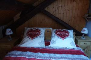 uma cama com duas almofadas vermelhas e brancas em Les 3 marmottes duplex proche de la station Les Karellis em Montricher-Albanne