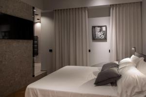a bedroom with a bed with white sheets and pillows at Suite Carolina HOME SUITE HOME in Pescara