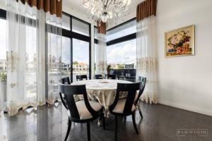 ein Esszimmer mit einem Tisch und Stühlen sowie großen Fenstern in der Unterkunft stunning prestige residence in Gold Coast