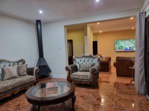 Sala de estar con sofás y mesa de centro en 11-on-RobRoy calming space with 3 bedrooms&pool, en Hillcrest