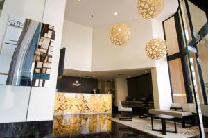 a lobby with tables and chairs and pendant lights at Park Regis North Quay in Brisbane