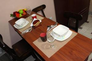 una mesa de madera con un plato y copas de vino. en Rinconcito Caleño!!, en Cali