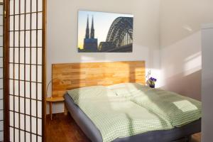 a bedroom with a bed and a painting on the wall at Apartment11 Wartburg in Cologne
