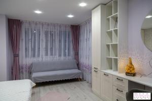 ein Schlafzimmer mit einem Bett und einem Waschtisch mit einem Spiegel in der Unterkunft Rose Valley Aroma Apartment in Kasanlak