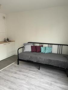 een bed met verschillende kussens in een kamer bij Appartement idéalement placé in Villeparisis