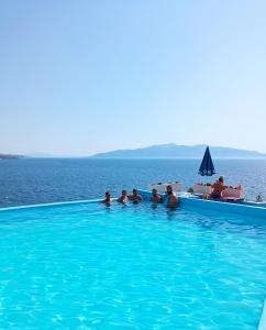 a group of people in a swimming pool overlooking the ocean at Apartments Romario in Sarandë