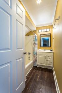 a bathroom with a shower and a sink and a door at St George Inn in St. George Island