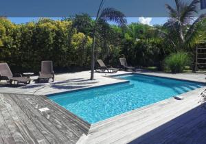a swimming pool in a yard with chairs and trees at VILLA Ti'OUITE in Surgy +4 photos