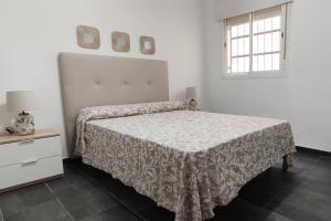 a white bedroom with a bed and a window at Porvenir in Seville