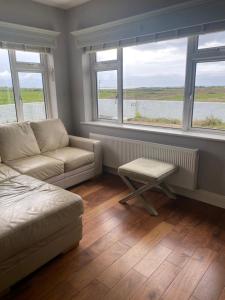 uma sala de estar com um sofá e duas janelas em Private House, Wild Atlantic Way, Spanish Point Road, Miltown Malbay em Miltown Malbay