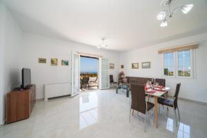 a dining room and living room with a table and chairs at Villa Erasmia- House 2 upper floor in Sarláta