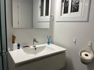a bathroom with a sink and a mirror and a toilet at Precioso Bajo en 2a línea de mar in Segur de Calafell +31 photos