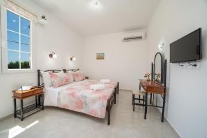 a bedroom with a bed and a flat screen tv at Villa Erasmia- House 2 upper floor in Sarláta +47 photos