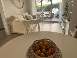a bowl of oranges sitting on a table in a living room at Precioso Bajo en 2a línea de mar in Segur de Calafell