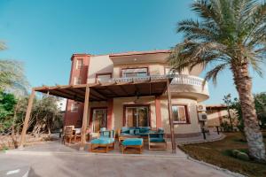 uma casa com um pátio com cadeiras e uma varanda em Luxury private villa with pool em Hurghada