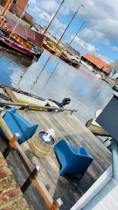 vistas a un puerto deportivo con sillas azules en un muelle en Woonboot 4 Harderwijk, en Harderwijk