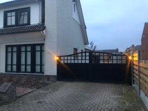 a house with a black gate and a fence at Guesthouse 66 in Lommel