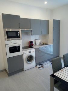 a kitchen with a washing machine and a washer at MON PETIT COIN DE PARADIS in Puyoô