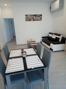 a dining room with a table and chairs and a bed at MON PETIT COIN DE PARADIS in Puyoô