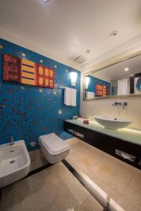 a bathroom with a sink and a toilet and a mirror at Holiday Inn Kuwait Al Thuraya City, an IHG Hotel in Kuwait