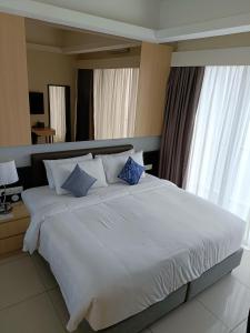 una camera da letto con un grande letto bianco con cuscini blu di The ECON at Genting Highlands a Resorts World Genting